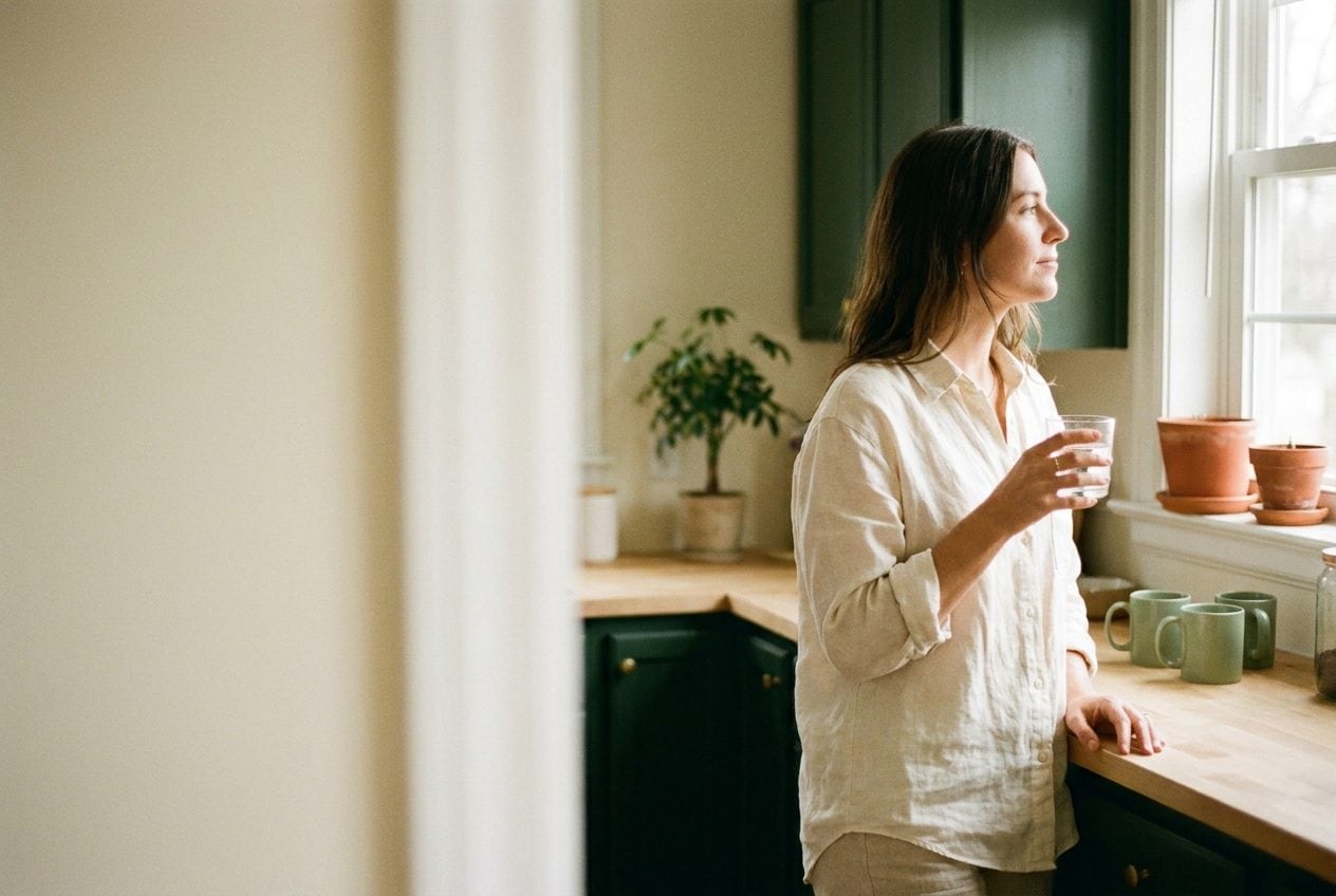 Personne détendue dans une cuisine lumineuse le matin, ambiance calme et apaisée